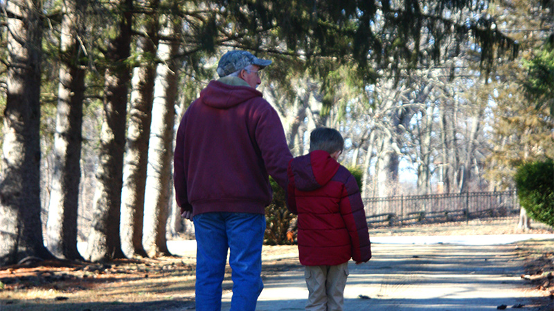 Outdoor photo of senior walking with child